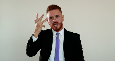 Upset man arguing to camera. Angry business man talking to camera gesturing with hands