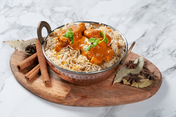 Indian spicy Butter Chicken Biryani Served in a dish isolated on wooden board side view on grey background