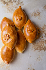 Fried homemade pies with potatoes on the kitchen table. Grandma's recipe. View from above.