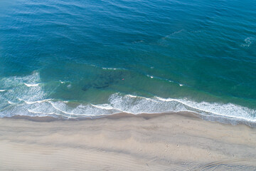 aerial view of the waves on the shore of a beach, summer concept
