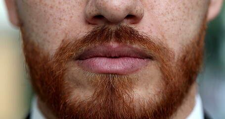 Serious redhead man lips and mouth close-up with red beard