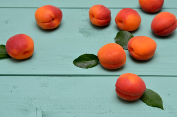fresh apricots scattered on green wooden background