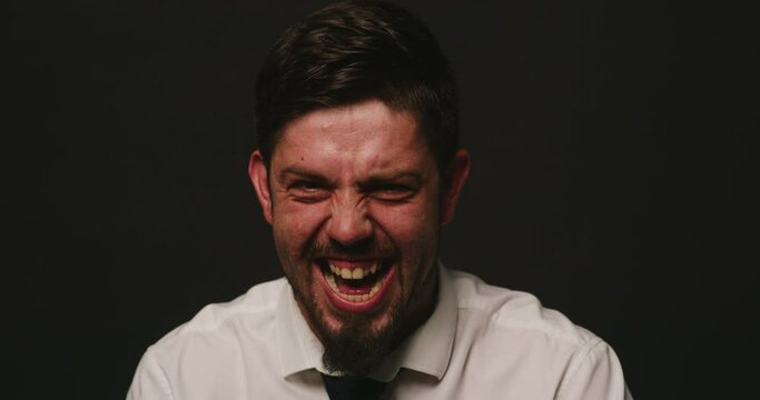 Portrait of a bipolar patient against black studio copy space background. Mentally ill man shouting and laughing showcasing multiple personalities suffering from schizophrenia personality disorder