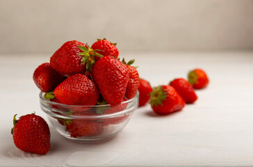 Fresh ripe strawberries in a plate on a white wooden background.Vegetarian organic berry.Healthy food.Vitamins.Copy space.Space for text