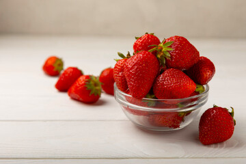 Fresh ripe strawberries in a plate on a white wooden background.Vegetarian organic berry.Healthy food.Vitamins.Copy space.Space for text