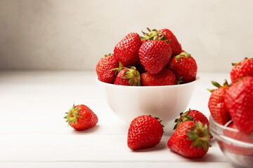 Fresh ripe strawberries in a plate on a white wooden background.Vegetarian organic berry.Healthy...