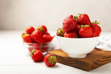 Fresh ripe strawberries in a plate on a white wooden background.Vegetarian organic berry.Healthy food.Vitamins.Copy space.Space for text