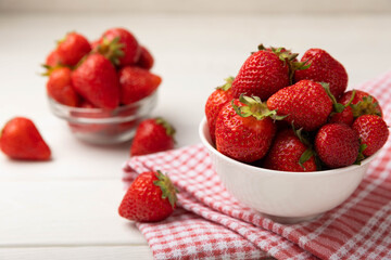 Fresh ripe strawberries in a plate on a white wooden background.Vegetarian organic berry.Healthy food.Vitamins.Copy space.Space for text