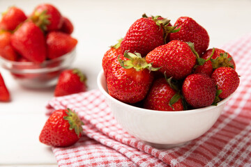 Fresh ripe strawberries in a plate on a white wooden background.Vegetarian organic berry.Healthy food.Vitamins.Copy space.Space for text