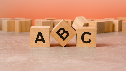 on a wooden background, light wooden blocks with the text ABC