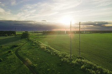 High voltage power lines at the field at the sunset time