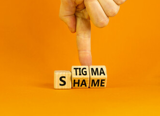 Stigma or shame symbol. Concept words Stigma or Shame on wooden cubes. Businessman hand. Beautiful orange table orange background. Business stigma or shame concept. Copy space.