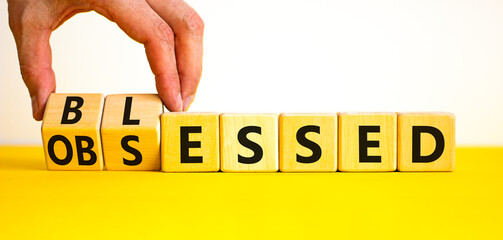 Blessed or obsessed symbol. Businessman turns wooden cubes and changes the concept word Obsessed to...