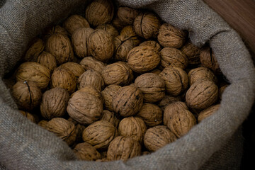 a large unpeeled dry walnut lies in a rough canvas bag, photo from the oriental bazaar