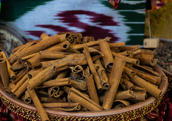 oriental seasoning brown whole cinnamon sticks lie heaped in a cup against the background of an...