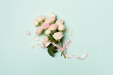 Small bouquet with rose flowers on color background, top view