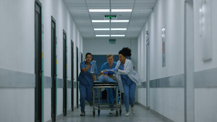 Medical team rolling gurney transporting patient to emergency room hospital.  - obrazy, fototapety, plakaty