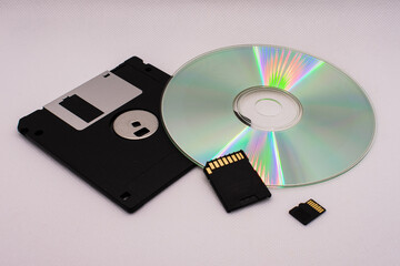 The evolution of memory storage. Floppy disk, CD, and memory cards on a white background close-up.
