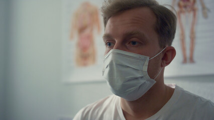Portrait patient waiting coronavirus test wearing protective mask in hospital.