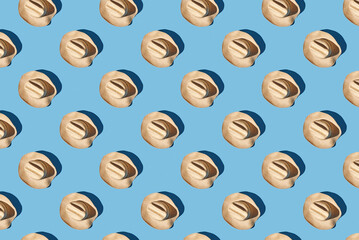 Pattern of straw hats on blue pastel background