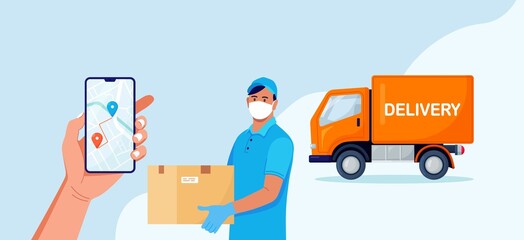 Delivery man with medical protective mask on his face holding package with yellow truck on background. Delivery during quarantine time. Safe shipping order. Online delivery app on phone screen