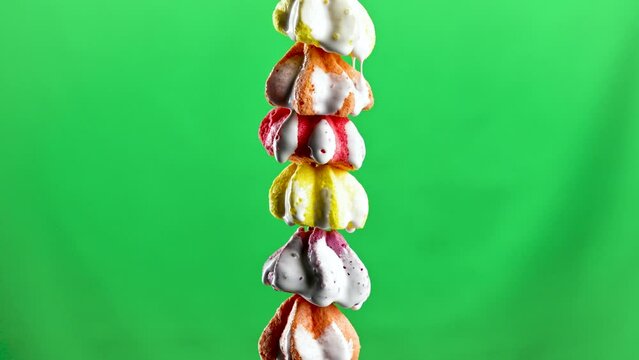 Colorful little bizet. Stock footage.A small neat crunchy cookie on a green background that stands on top of each other and which is poured with sugar syrup