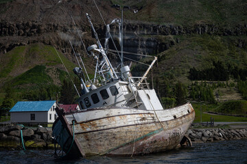 Tilted on its side fishing boat in the harbor of the town Seydisfjordur in Iceland