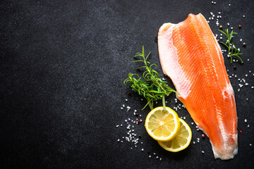 Fresh fish. Salmon fish, fresh raw fillet at black background. Top view with copy space.