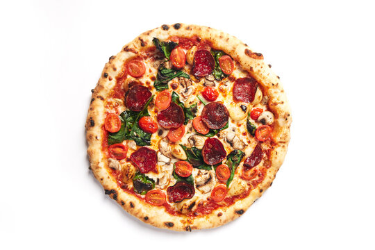 Top View Of Pizza Topped With Pepperoni, Tomato, Roasted Garlic, Mushroom And Spinach On A White Background