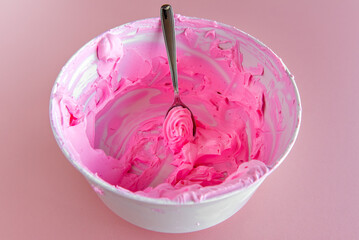 bowl with pink whipped cream scraping.