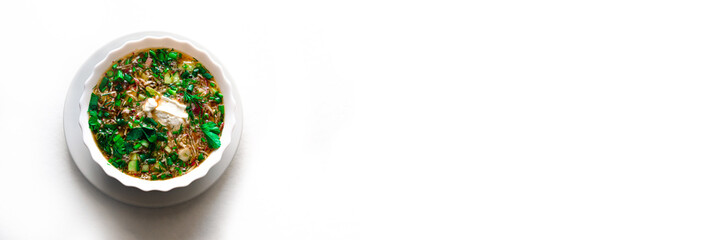 Summer cold soup - okroshka in a ceramic white bowl. on an isolated white background. Ingredients: potatoes, radishes, cucumbers, parsley, eggs.