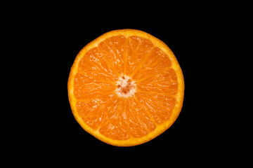 half of a mandarin is lying on a black background