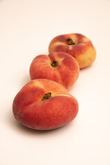 Fototapeta na wymiar Donut peaches in front of a yellowish white background