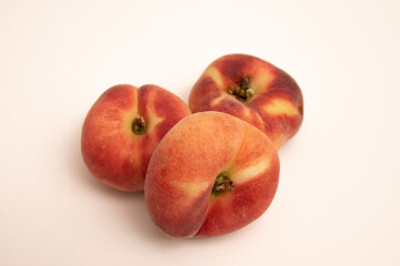 Donut peaches in front of a yellowish white background