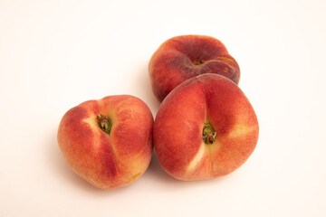Donut peaches in front of a yellowish white background
