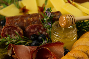 Typical aperitif of the Dolomites with ham, salame, cheese, puccia and honey