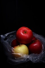 red and green apples in a plastic bag