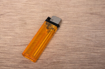 Close-up photo of a transparent orange gas lighter - obrazy, fototapety, plakaty