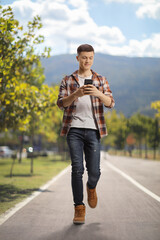 Guy walking outdoors and using a smartphone