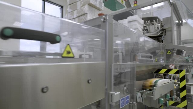 Pharmaceutics. Pharmaceutical worker operates blister packaging machine. Medical products manufacturing in a modern factory - operator at modern industrial plant