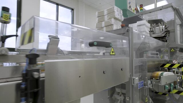 Pharmaceutics. Pharmaceutical worker operates blister packaging machine. Medical products manufacturing in a modern factory - operator at modern industrial plant