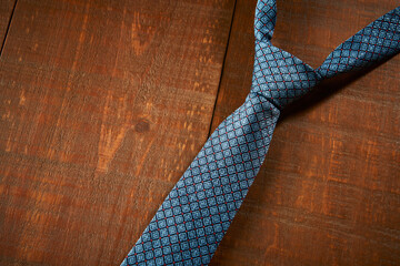 Gravata azul  estampada com detalhes em vermelho, em fundo de madeira rustica