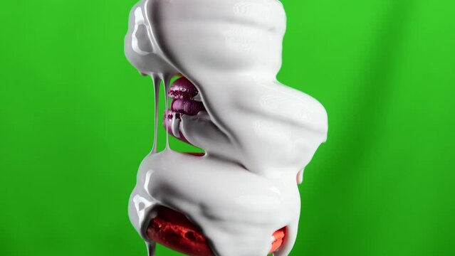 Green background. Stock clip.Maccaroons of different colors are watered,which is watered with white sugar.
