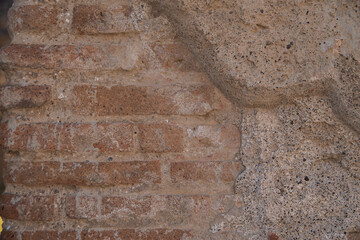 Wall of a house in the ancient city of Pompeii. Old brickwork, historical value. Antique Italy.