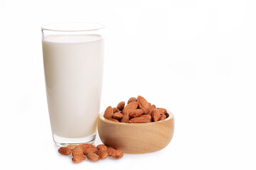 Glass of almond milk with almonds in wooden bowl on white background.