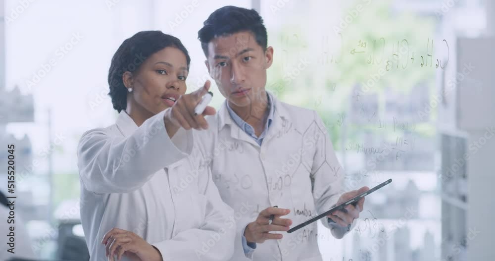 Leinwandbilder Two scientists using a digital tablet while brainstorming equations and formulas on a glass wall in a lab. Forensic pathologists analyzing data and research. Clinical researchers developing a theory