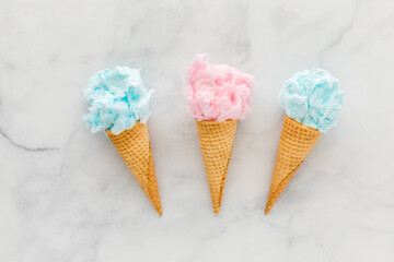 Three waffle cones filled with cotton candy, against a light background.