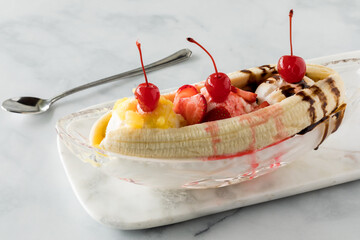 Banana split ice cream dessert topped with maraschino cherries.