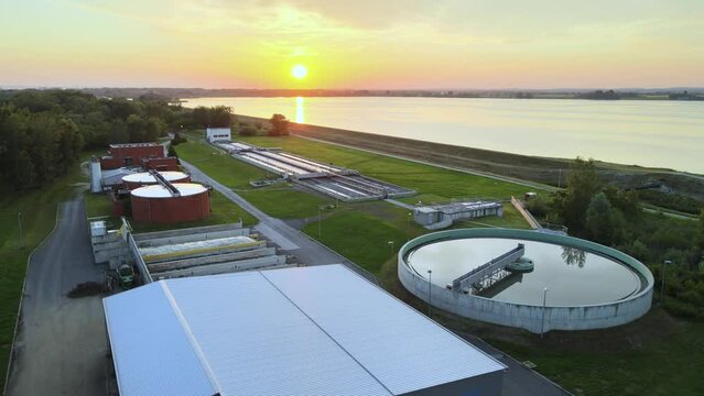 Sunset Aerial of drinking Water purification system plant in natural environment with green forest and river