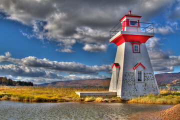 lighthouse with clouds and pond
